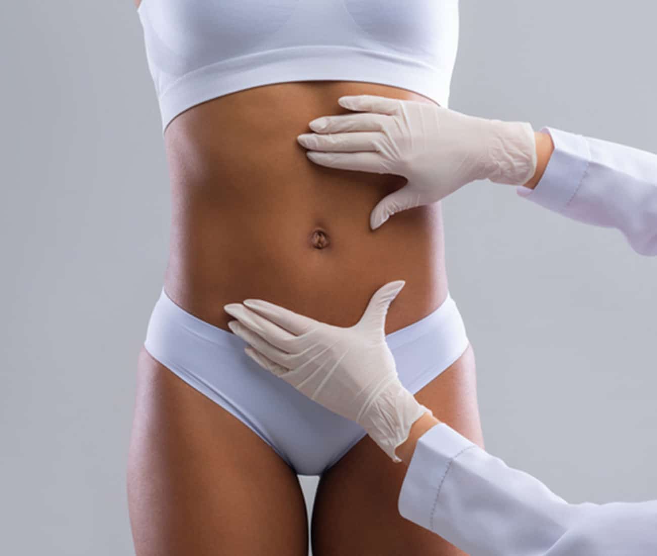 Doctor checking patients abdomen for body sculpting treatment