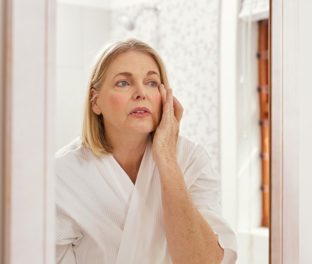 a woman standing in front of a mirror posing for the camera